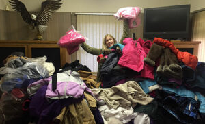 Image of Michelle sorting through the many coats we received at last year’s coat drive!